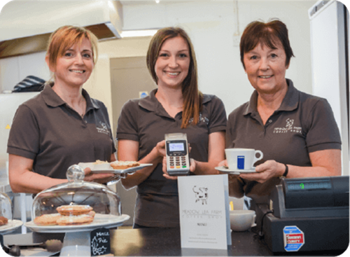 Staff from Meadow Lea Farm Coffee Shop holding cake, coffee and Handepay Card Payment Machine