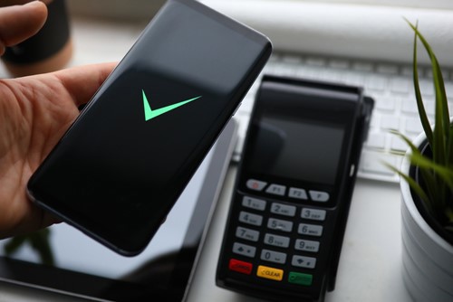 Phone screen showing a green tick with card payment machine near it
