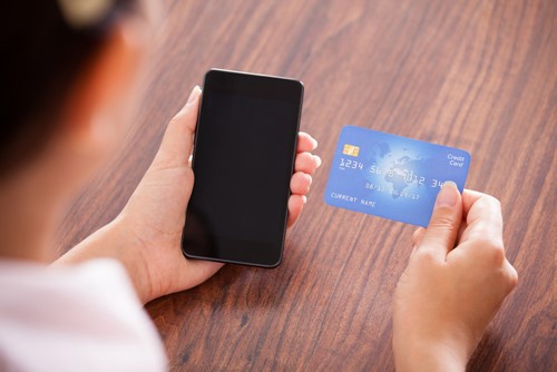 Person holding phone and a card payment