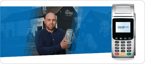 Owner of The Archer holding up a Handepay Portable Card Machine