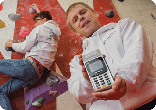 Person at a climbing center holding Handepay Card Payment Machine