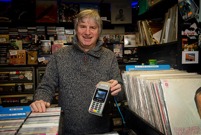Martin owner of Missing Records holding Handepay Card Machine which saves him money