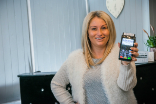 Owner of Beauty by Kathryn holding Handepay Card Machine