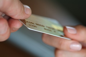 Payment card held at either end by hands