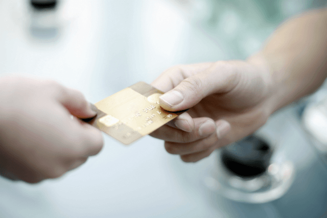 Gold card being exchanged between hands