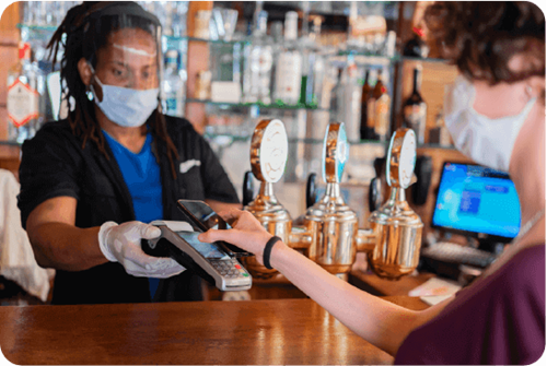 Contactless payment taking place at a bar during covid