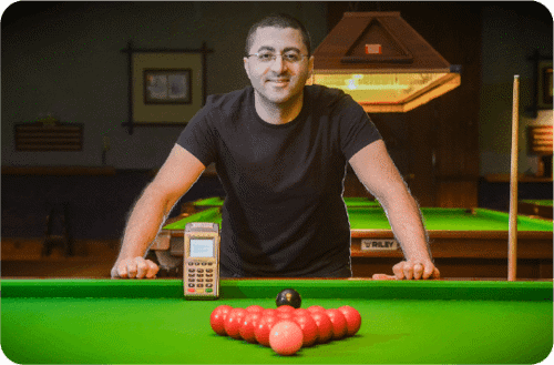 Snooker club owner at snooker table with card machine